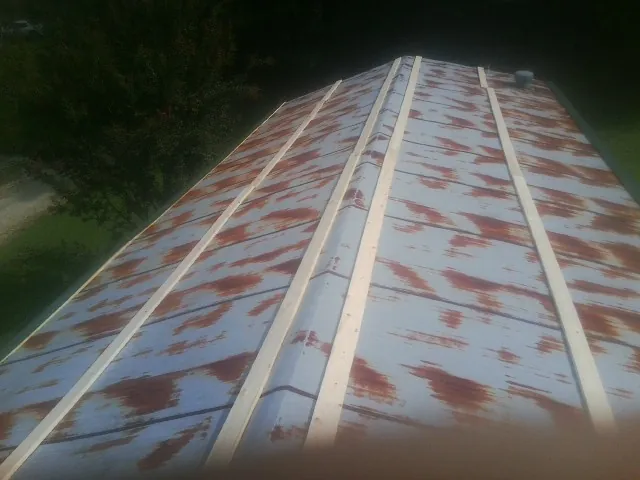 Rusted metal roof panels with new wood purlins before replacement — Storm Damage Roof Repair in Pamplico by Roofing Brothers