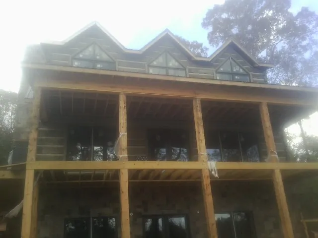 Dormers and porch framing on a large log home under construction — Roof Coating work by our crew in Pamplico