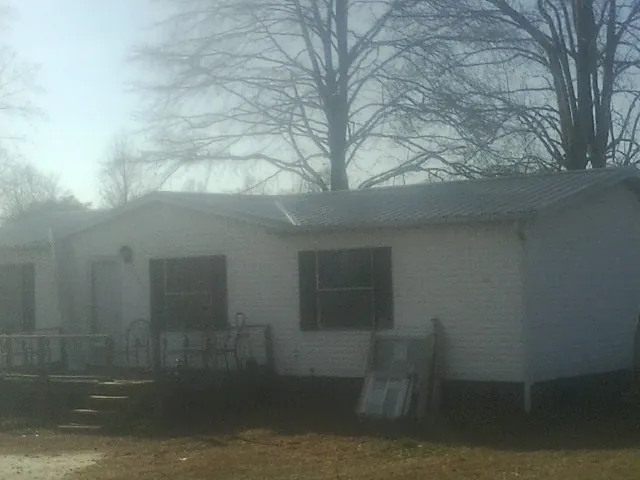 New metal roof on a white painted brick home on a foggy morning in Pamplico