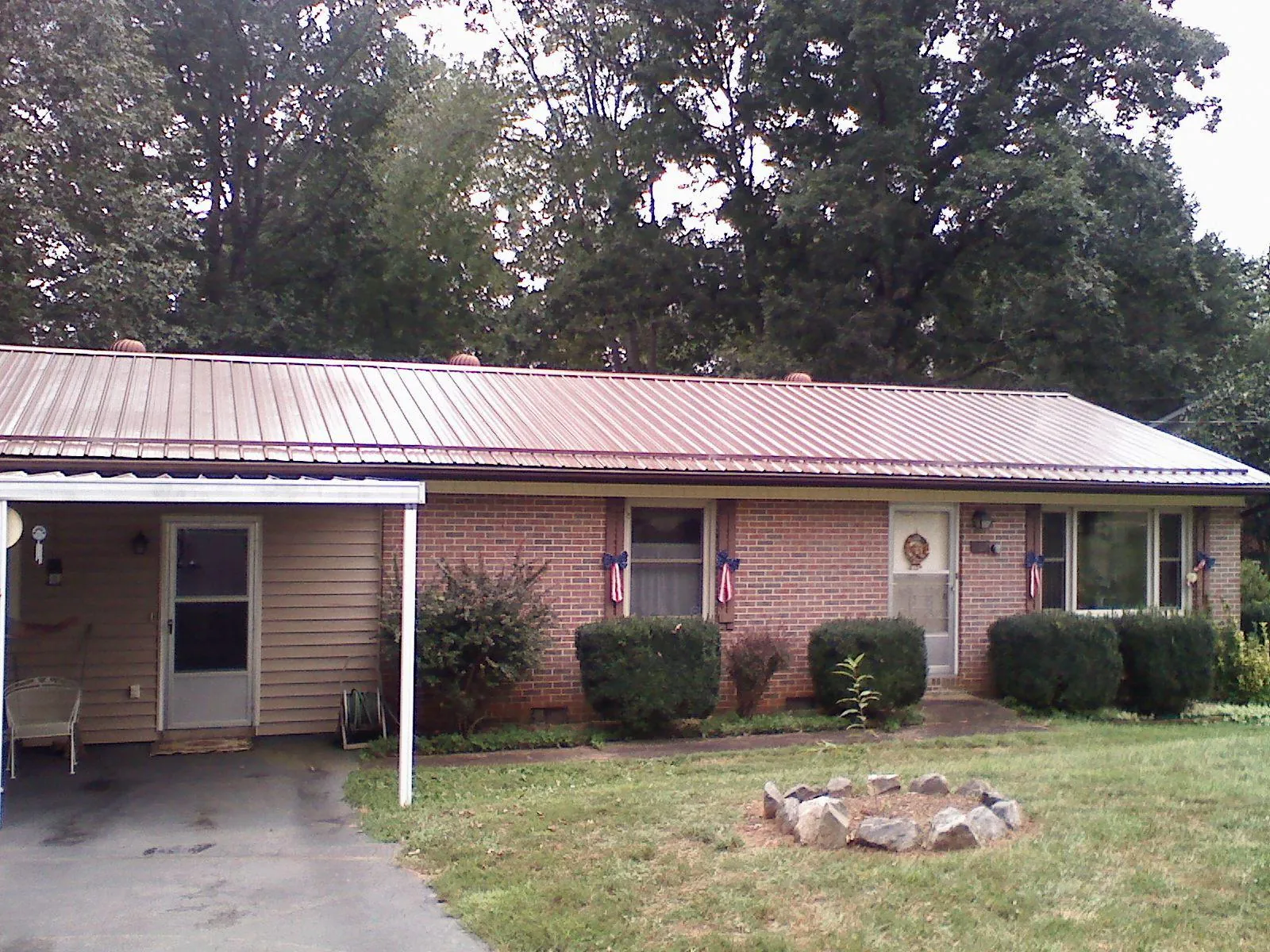 Bronze metal roof and carport on a brick ranch home — Roof Repair work by our crew in Pamplico